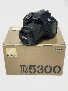 نمای روبروی دوربین Nikon D5300 با لنز 18-55 روی جعبه اصلی