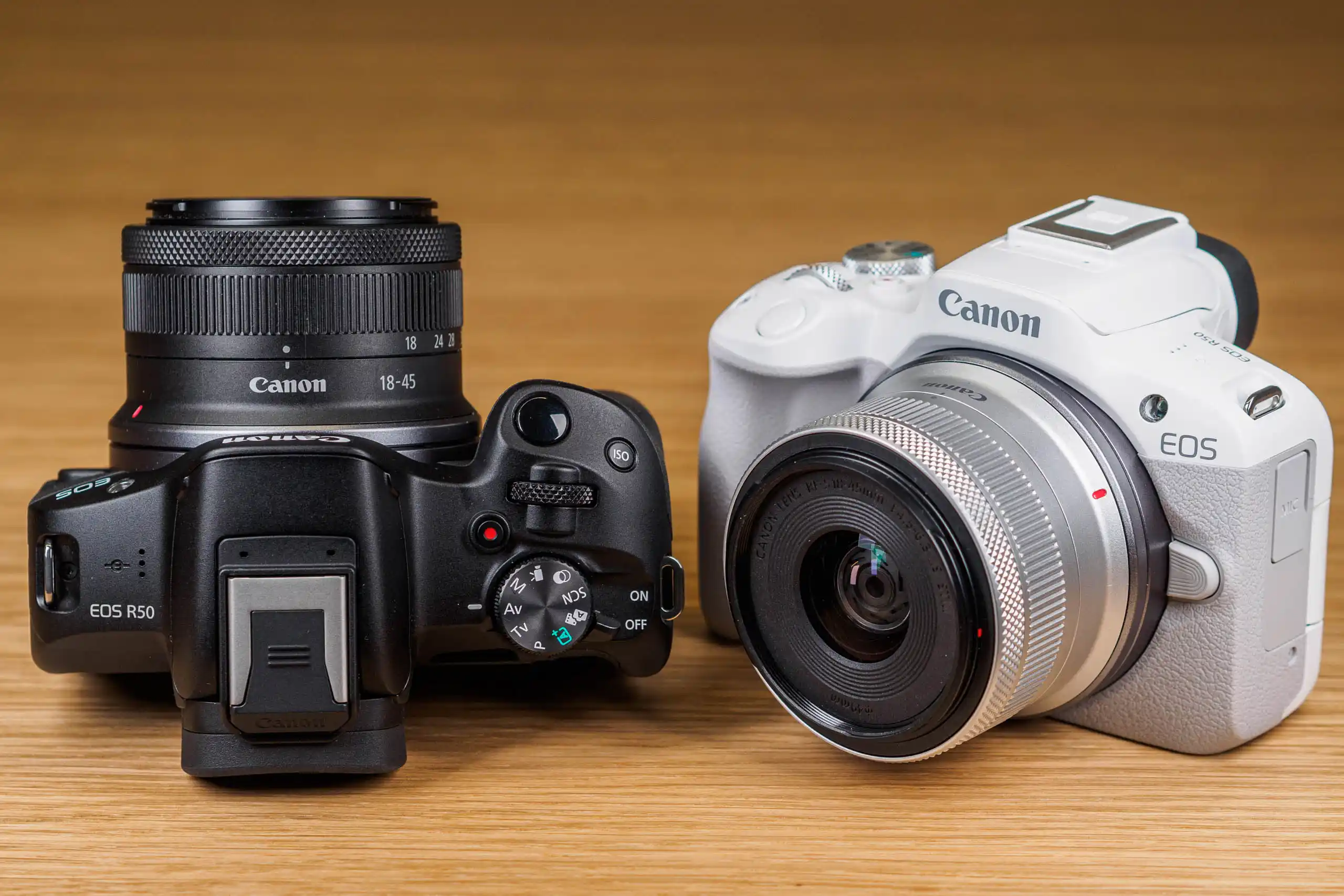 عکس دوربین Canon EOS R50 با لنز RF-S 18-45mm قرار گرفته روی سطح صاف، نمایش طراحی سبک و بدنه جمع‌وجور