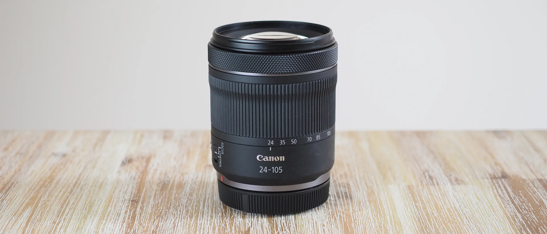 نمای نزدیک از لنز Canon RF 24-105mm f/4-7.1 IS STM ، نمایش طراحی جمع‌وجور، حلقه زوم همه‌کاره و لرزشگیر اپتیکال برای عکاسی سفر و پرتره