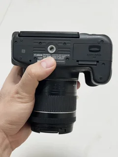 نمای زیر دوربین Canon 750d با لنز 18-55 IS II؛ محل اتصال پایه و باتری
