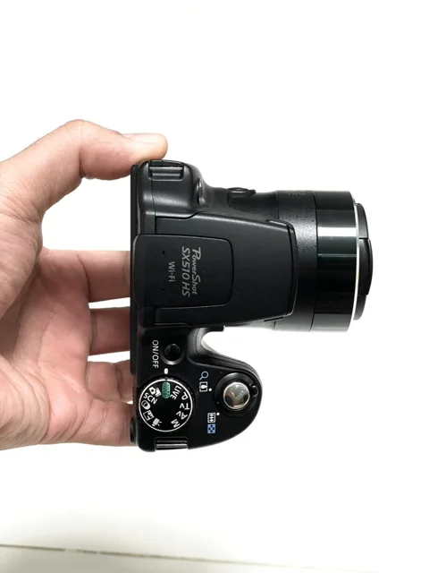 نمای بالای دوربین Canon PowerShot SX510 HS؛ بررسی بخش بالایی لنز و دکمه شاتر
